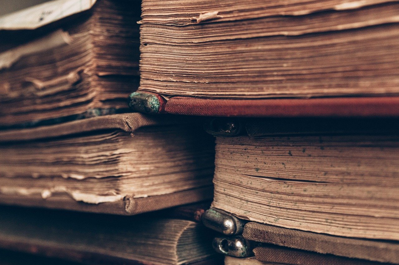 stacks of old books with distressed covers and pages
