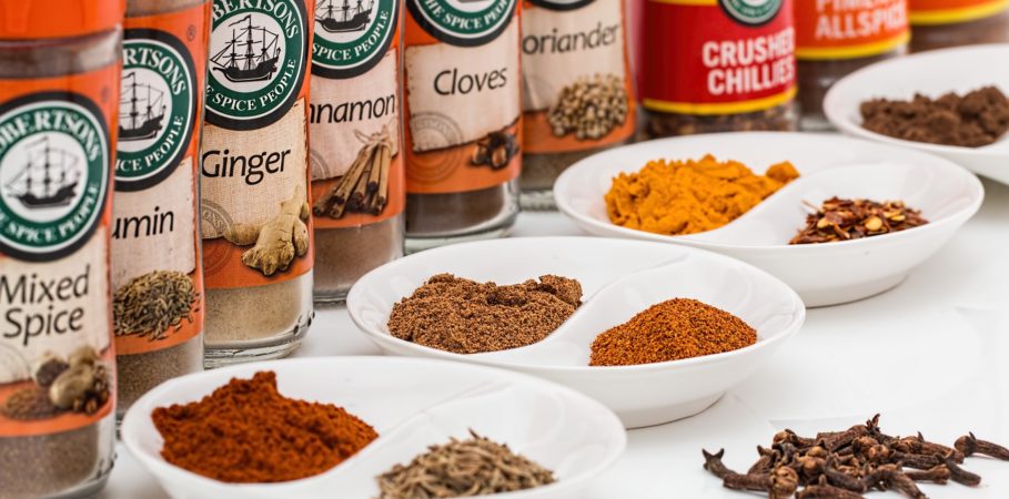 A row of spices (ginger, cloves, crushed chili pepper, etc.)