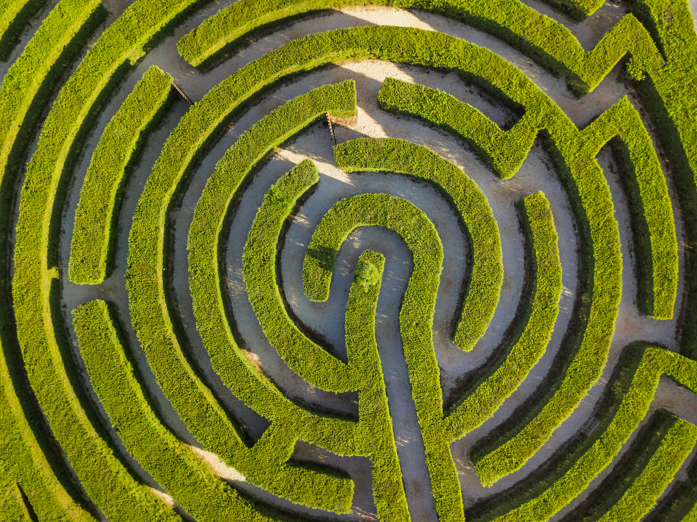 Bird-eye view of a large circular hedge maze, symbolizing how easy it is to get lost in the content localization process.
